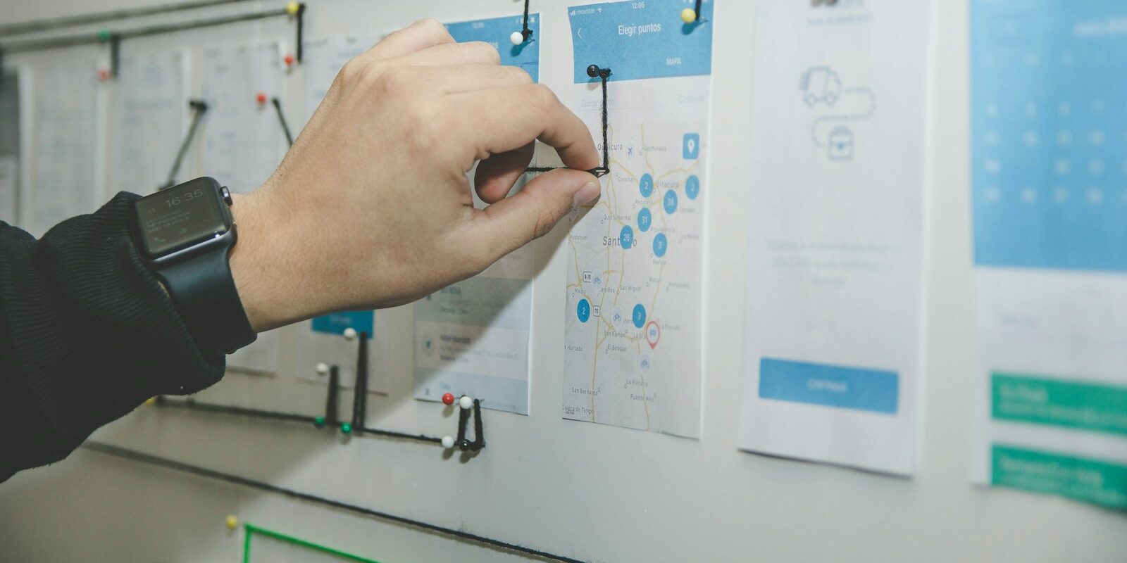 person working on blue and white paper on board